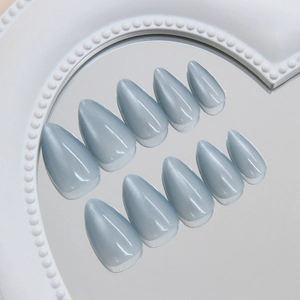 Elegant almond cat eye press on nails in Morandi blue on a reflective mirror tray