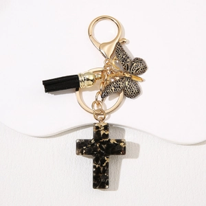 Custom resin cross keychain with black tassel and gold foil butterfly pendant on white stand