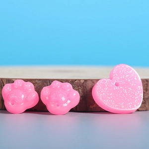 DIY pink glitter resin molds with cat paw and heart pendant shapes on wooden background