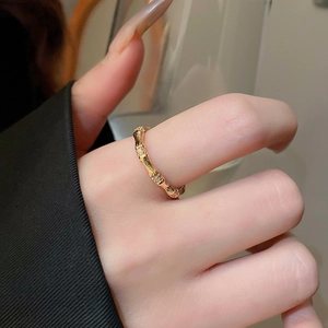 Detail of gold bamboo-style ring with sparkling zircon inlays on model's finger