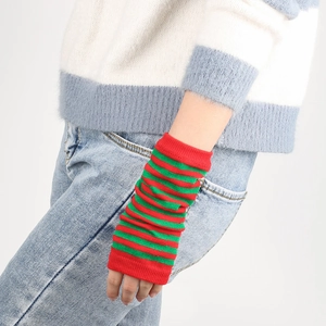 Detailed close-up of red and green striped knit arm warmers with soft ribbed texture