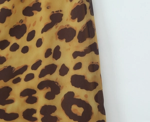 Detail shot of lightweight leopard print chiffon fabric in yellow and brown tones