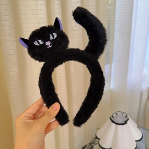 Detail of plush black cat headband with purple ears and embroidered facial features
