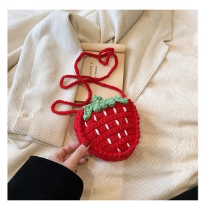 Detailansicht der handgefertigten Erdbeer-Häkeltasche mit roter Textur und grünen Blättern