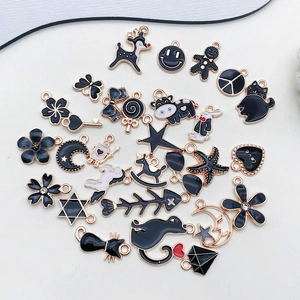 Flat lay of diverse black and white enamel alloy charms with gold-plated edges for DIY