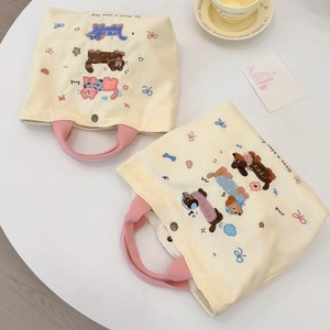 Détail de sacs à lunch en velours côtelé avec broderies mignonnes de chat et chien