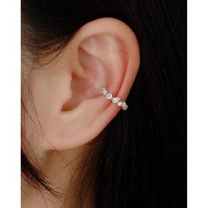 Close-up of a silver cuff earring set with sparkling cubic zirconia on a model's ear