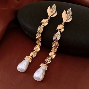 Detailed shot of vintage gold leaf earrings with rhinestones and Baroque pearl drops