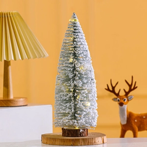 Mini flocked Christmas tree with warm LED lights and a wooden base for table decoration