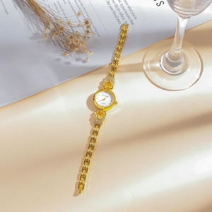 Elegant gold women's bracelet watch with diamond accents and white round dial stylish piece