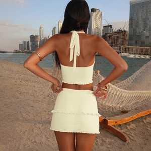 Rear view of trendy beige halter top and mini skirt set with ruffle details on beach
