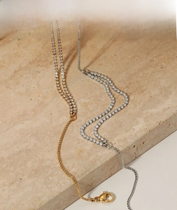 Detail of gold and silver tennis anklets with double-row zircon and box chain connectors