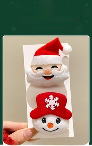 Detailed view of plush Santa and snowman brooches with premium embroidery craftsmanship
