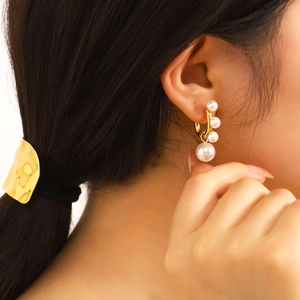 Élégantes boucles d'oreilles créoles en acier doré 18 carats avec perles sur modèle
