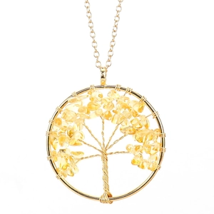 Macro detail of handmade life tree pendant with gold wire and yellow crystal stones
