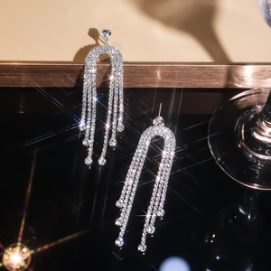Macro shot of sparkling rhinestone tassel earrings with shimmering starburst lighting effects