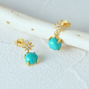 Macro shot of S925 silver gold-plated star earrings with turquoise and white zircon