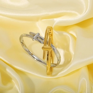 Elegant gold and silver knot bangles in polished stainless steel on silk background