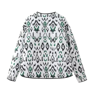 Detail of bohemian geometric print and diamond quilting on white cotton jacket back