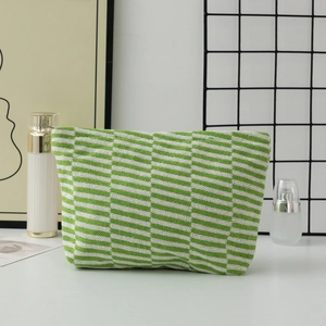 Close-up of green and white striped knit cosmetic bag with detailed woven texture