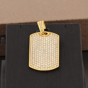 Macro shot of gold hip-hop dog tag pendant fully encrusted with shimmering crystals
