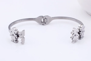Detailed view of silver stainless steel open bracelet with boy and girl charms