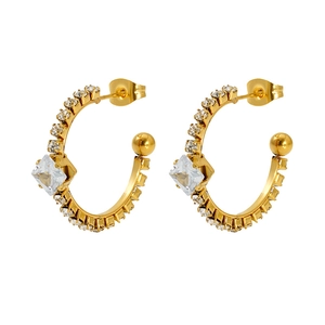 Macro view of gold C-shaped earrings with square crystal and small diamond row details