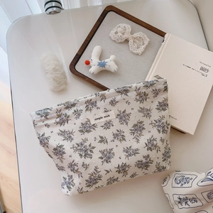 Detailed view of floral cotton makeup bag with simple wish label and purple flower print