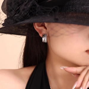 Close-up of double-layer C-shaped silver earrings with sparkling crystals on model
