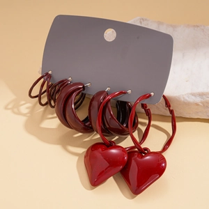 Detail view of a six-piece red heart and geometric hoop earring set on a display card