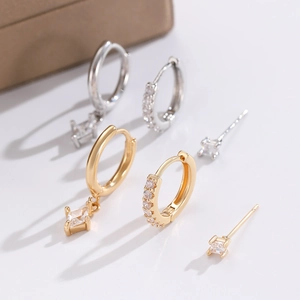 Macro detail of gold and silver hoop earrings set featuring sparkling zircon stones