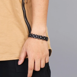 Detail of man wearing black chunky metal chain bracelet on wrist with trendy style