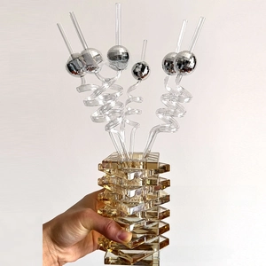 Detail of amber glass base and silver disco ball mirror straws for party decor
