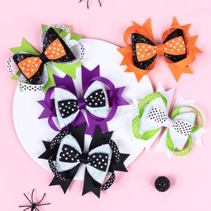 Detailed set of 5 Halloween bow hair clips with glitter and polka dots on a pink surface