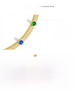 Detail of mirror polished gold snake chain necklace with green, blue, and white zircon stones