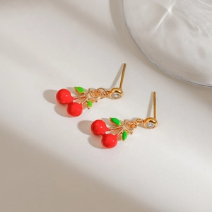 Sweet red cherry stud earrings with gold stem and crystal detail on a ripple background