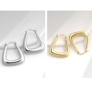 Detail view of U-shaped minimalist earrings in polished gold and silver metallic finishes