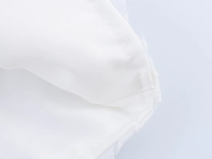 Gros plan sur le tissu blanc tissé avec détails en maille fine et coutures précises