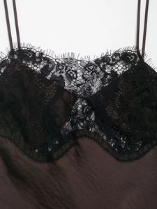 Close-up of black eyelash lace trim on a dark brown silk satin camisole dress