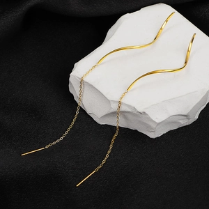 Elegant gold wave-shaped threader earrings with long tassels on minimalist stone base