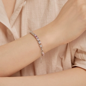 Macro shot of silver tennis bracelet featuring colorful square zircons and an adjustable chain