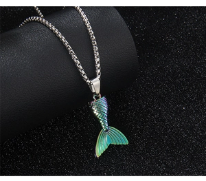 Macro shot of colorful mermaid tail pendant with iridescent scales on a silver chain