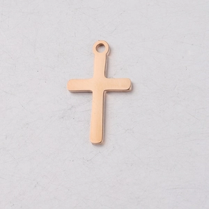 Dettaglio del ciondolo a croce in oro rosa con finitura a specchio e anello di aggancio