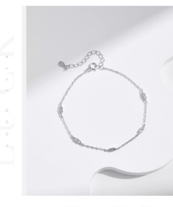 Macro shot of S925 sterling silver bracelet showing small zircon charms and extension chain