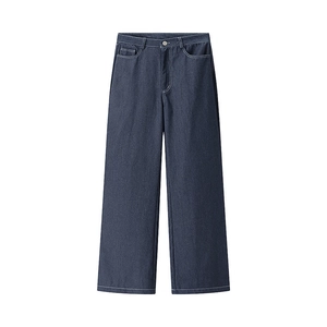 Détail du pantalon large en jean bleu foncé avec surpiqûres contrastées et poches avant