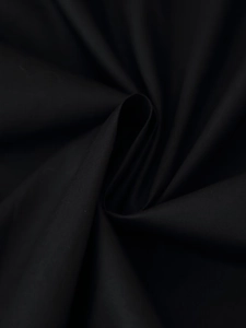 Macro shot of black pleated fabric showing dense matte texture and natural drape detail