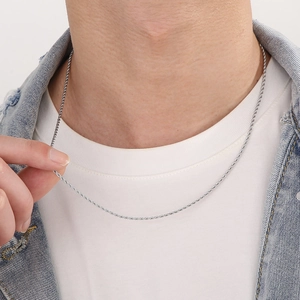 Collana a corda d'argento da uomo mostrata sul collo di un modello con outfit casual