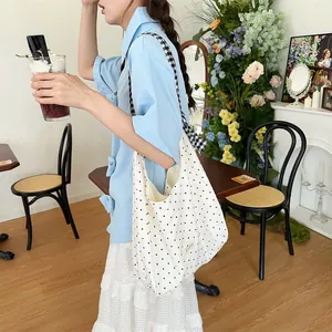Polka dot canvas tote bag detail featuring checkered strap and Sunshine brand label