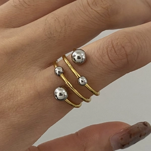 Three-layer 18k gold and silver stainless steel spiral ring with ball accents on hand