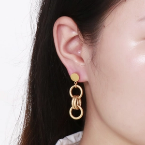 Boucles d'oreilles dorées à trois anneaux avec finition métal brossé sur mannequin